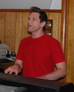 Peter J Hopkins playing a keyboard and singing